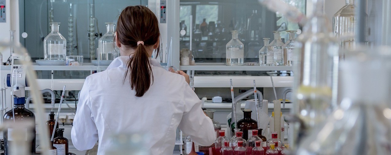 A woman studies mold in a lab.