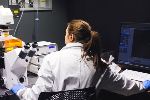 Female scientist looking in microscope.